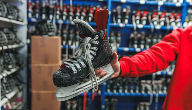 Personne montrant un patin à glace dans une boutique de patins