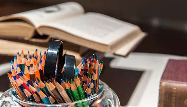Pot de crayon et livre ouvert