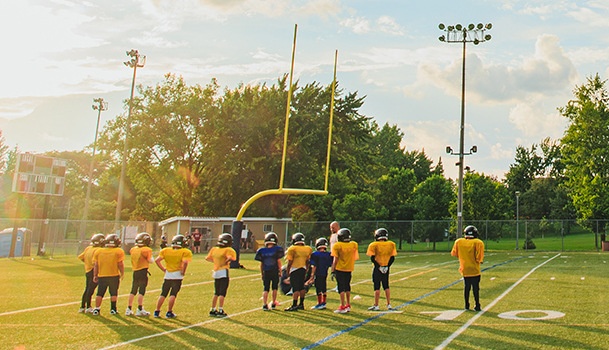 Groupe de personnes jouant au football sur un terrain sportif