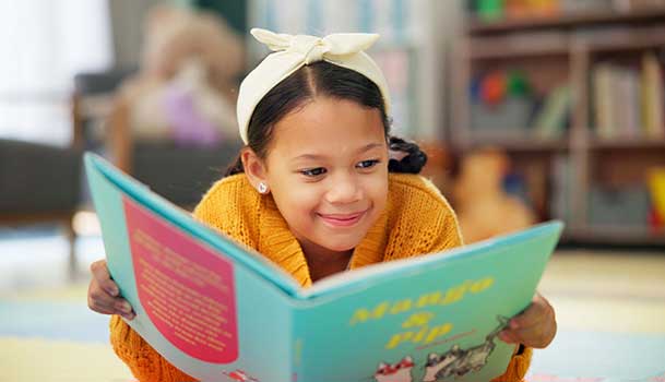 Une enfant qui lit un livre dans une bibliothèque