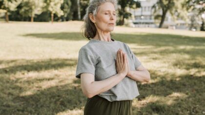 Une personne de 50 ans et plus qui fait du yoga dans un parc