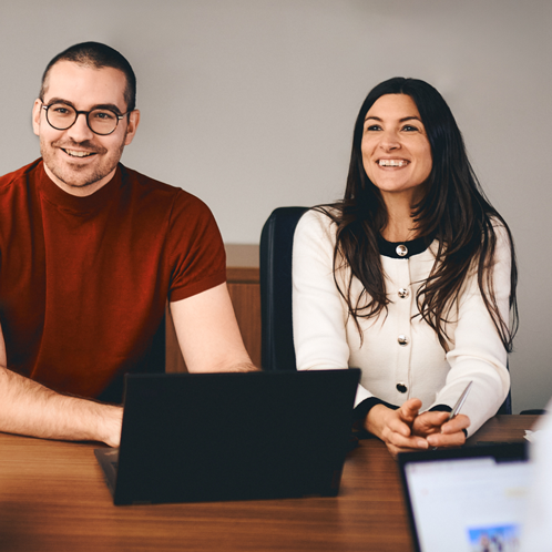 Femme et homme assis à un bureau avec un ordinateur.