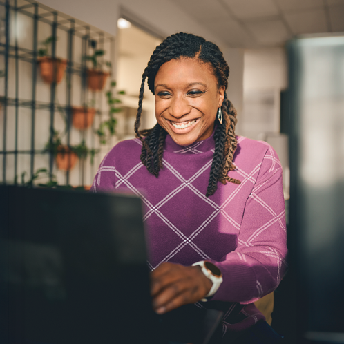 Dame assise qui travaille sur son ordinateur.