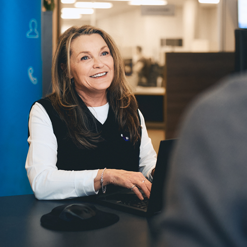 Dame assise à un bureau avec son ordinateur.