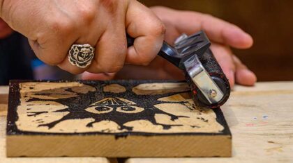 Personne qui grave sur un morceau de bois