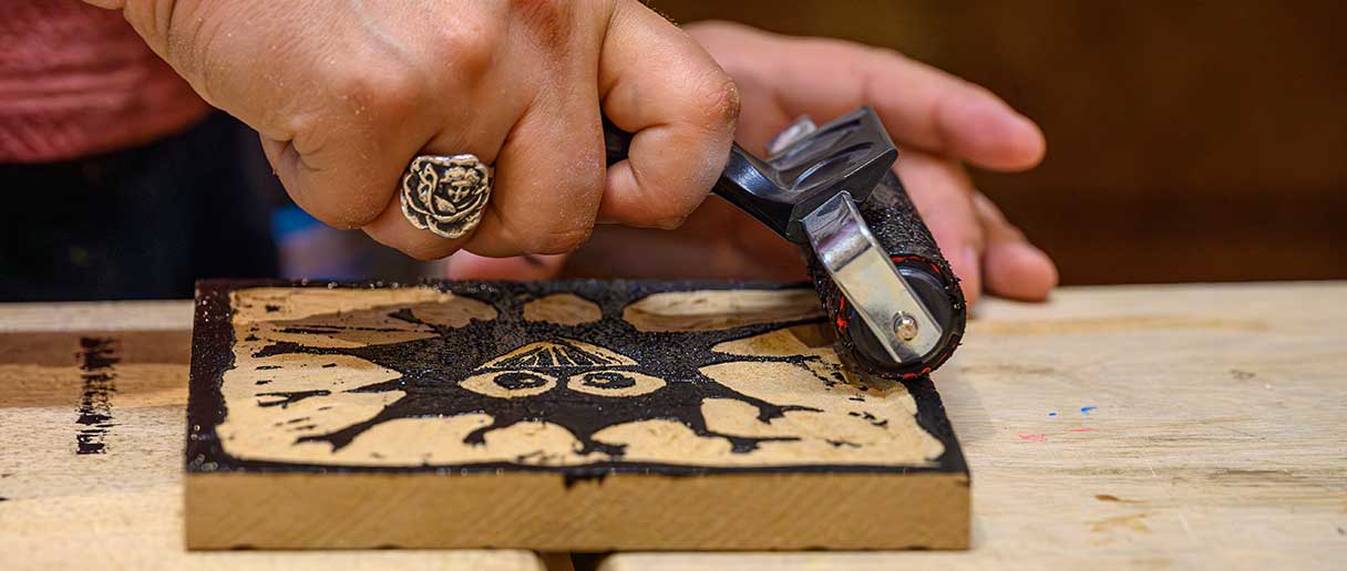 Personne qui grave sur un morceau de bois