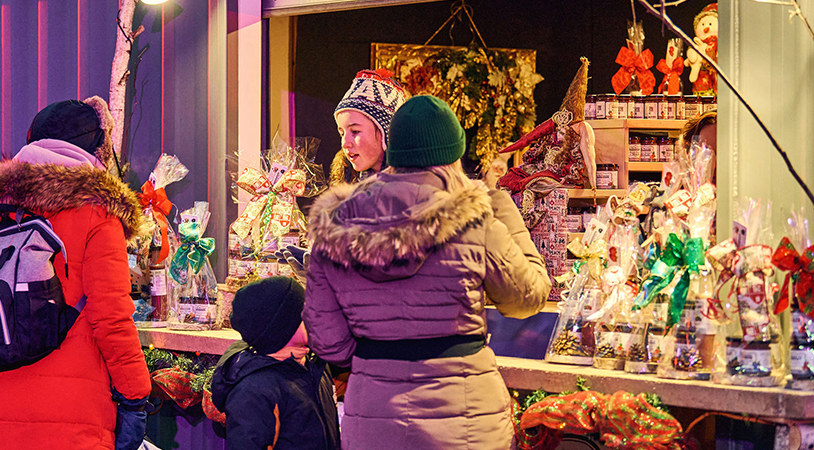 Des gens devant une boutique au Marché de Noël de Laval au Centre de la nature