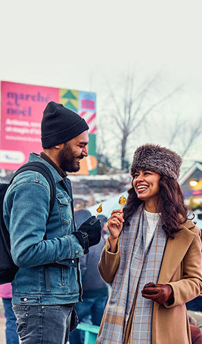 Des personnes dégustant de la tire au Marché de Noël de Laval au centre de la Nature
