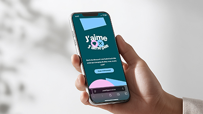 Quelqu'un qui tient un cellulaire dont l'écran affiche un jeu interactif intitulé J'aime / J'aime pas