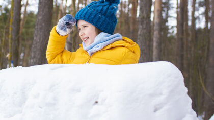Enfant derrière un château de neige