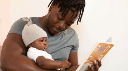Une papa qui fait la lecture à son poupon