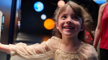 Fillette qui se promène au Cosmodôme avec un air émerveillé