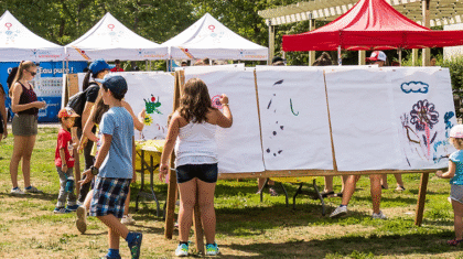 Des enfants qui font de la peinture ou de l'artisanat dans un parc