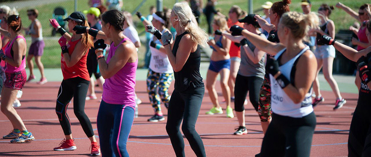 Des personnes qui prennent un cours de boxe dehors.