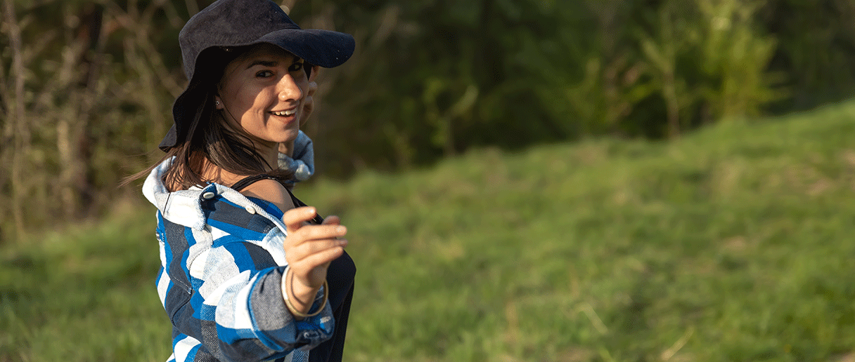 Une personne avec un chapeau country qui danse dans un parc
