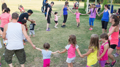Des enfants qui dansent avec leurs parents dans un parc
