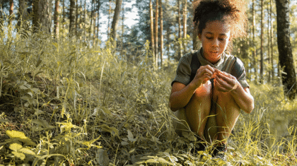 Enfant explorant la nature (herbes, fleurs)