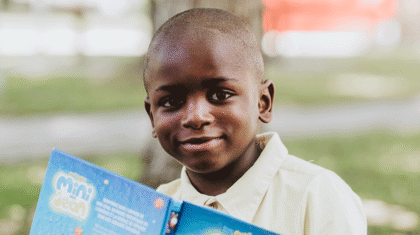 Un enfant qui lit un livre dehors
