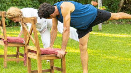 Deux personnes qui font du Pilates sur chaise dehors.