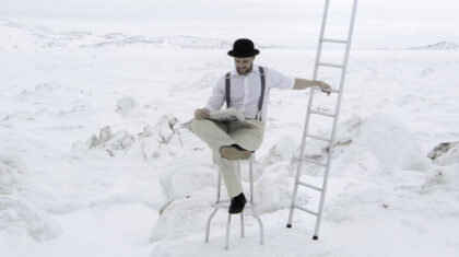Homme dans un décor blanc style hivernal avec une échelle