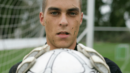 Un gardien de but qui tient un ballon de soccer entre ses mains