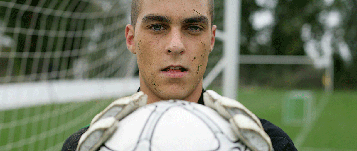 Un gardien de but qui tient un ballon de soccer entre ses mains